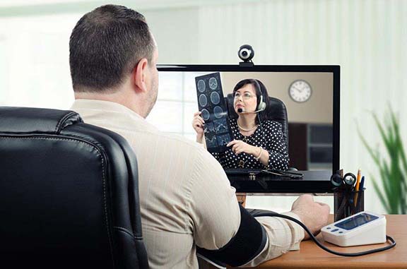 Image of patient having his blood pressure checked by a provider in a different location.