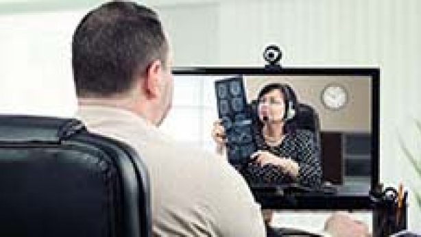 Image of patient having his blood pressure checked by a provider in a different location.