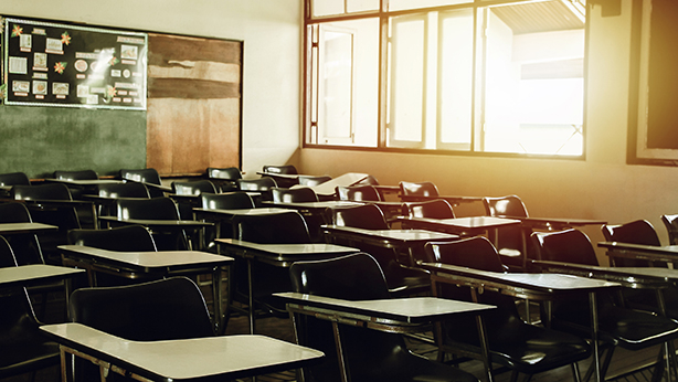 Desks in a classroom in the early morning light 